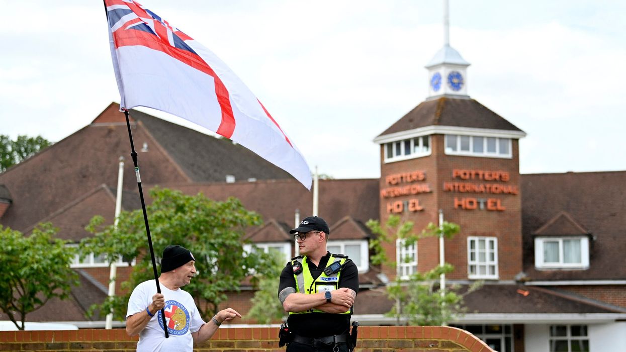 A protester wearing a 'Britain First' t-shirt waves a mixed Union Jack and St George's flag during a 'Enough is Enough' demonstration called by far-right activists outside a hotel housing asylum seekers in Aldershot on August 4, 2024. (Photo: Getty Images)