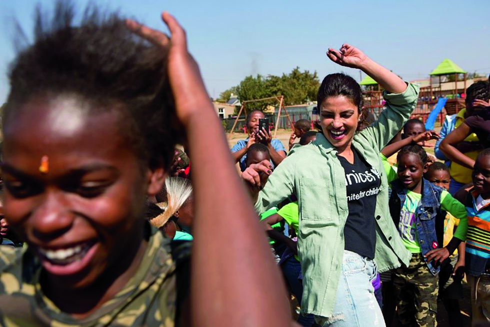 Dancing with children in Soweto South Africa as part of her work as a UNICEF Goodwill Ambassador