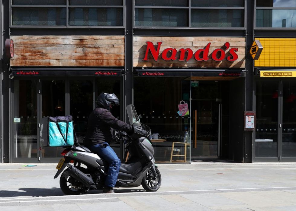 Deliveroo driver collects a takeaway order from Nando's in Aylesbury