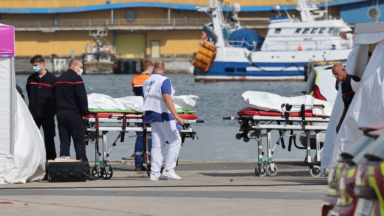 Firefighters and Civil Protection agents stand next to bags containing the bodies of migrants who died after the sinking of a migrant boat attempting to cross the English Channel to England, in Boulogne-sur-Mer, northern France, on September 3. (Photo: Getty Images)