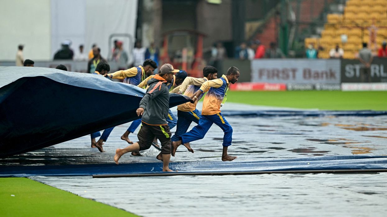 Groundsmen remove cover off the field at the start of the first day play of the first Test cricket match between India and New Zealand at the M Chinnaswamy Stadium in Bengaluru on October 16, 2024. (Photo: Getty Images)