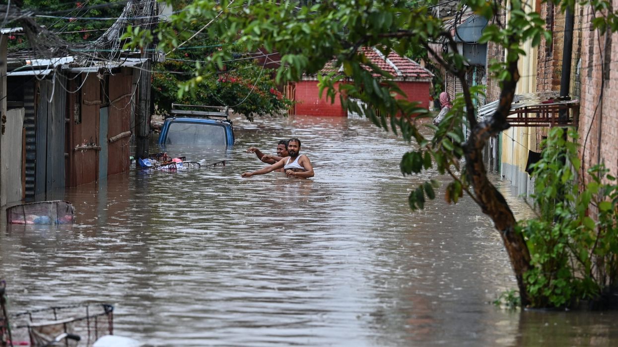 Local residents wade through flood waters after the Bishnumati river overflowed following heavy rainfall in Kathmandu, Nepal, on September 28, 2024. (Photo: Getty Images)