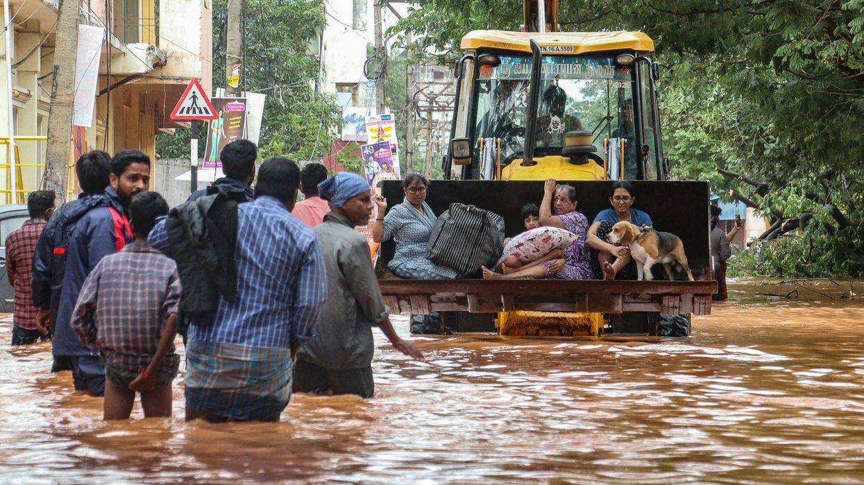 People move through a flooded street after heavy rainfall in Puducherry on December 1, 2024, following the landfall of cyclone Fengal in India's state of Tamil Nadu. (Photo: Getty Images)