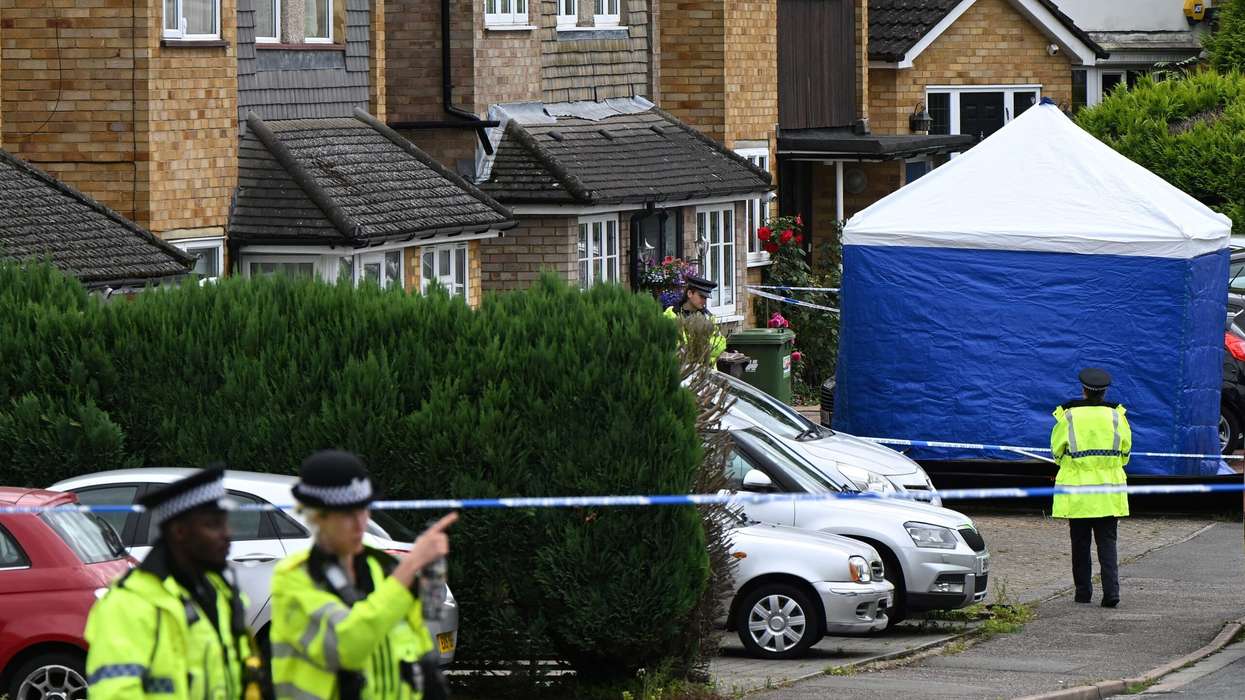 Police officers stand guard by a forensic team tent at Ashley Close in Bushey in the borough of Hertfordshire, north of London, on July 10, 2024 after a triple 'crossbow attack' murder. (Photo: Getty Images)