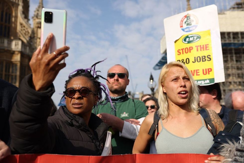 Protesters hold up placards during a demonstration against the sacking of 800 P&O workers, outside the Houses of Parliament in London, on March 21, 2022.