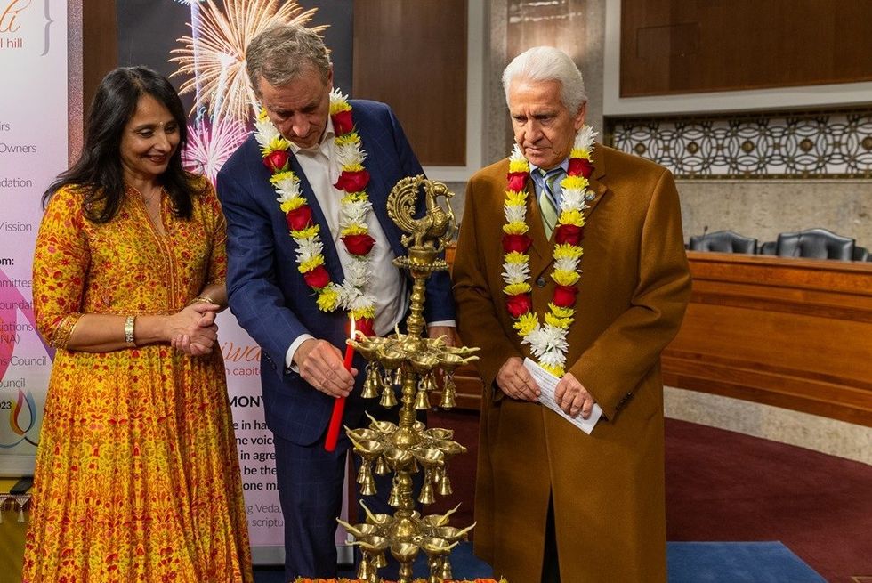 Representative Jim Costa CA 21 right Representative Matt Cartwright PA 8 center and Hindu American Foundation Executive Director Suhag Shukla light the diya right 1