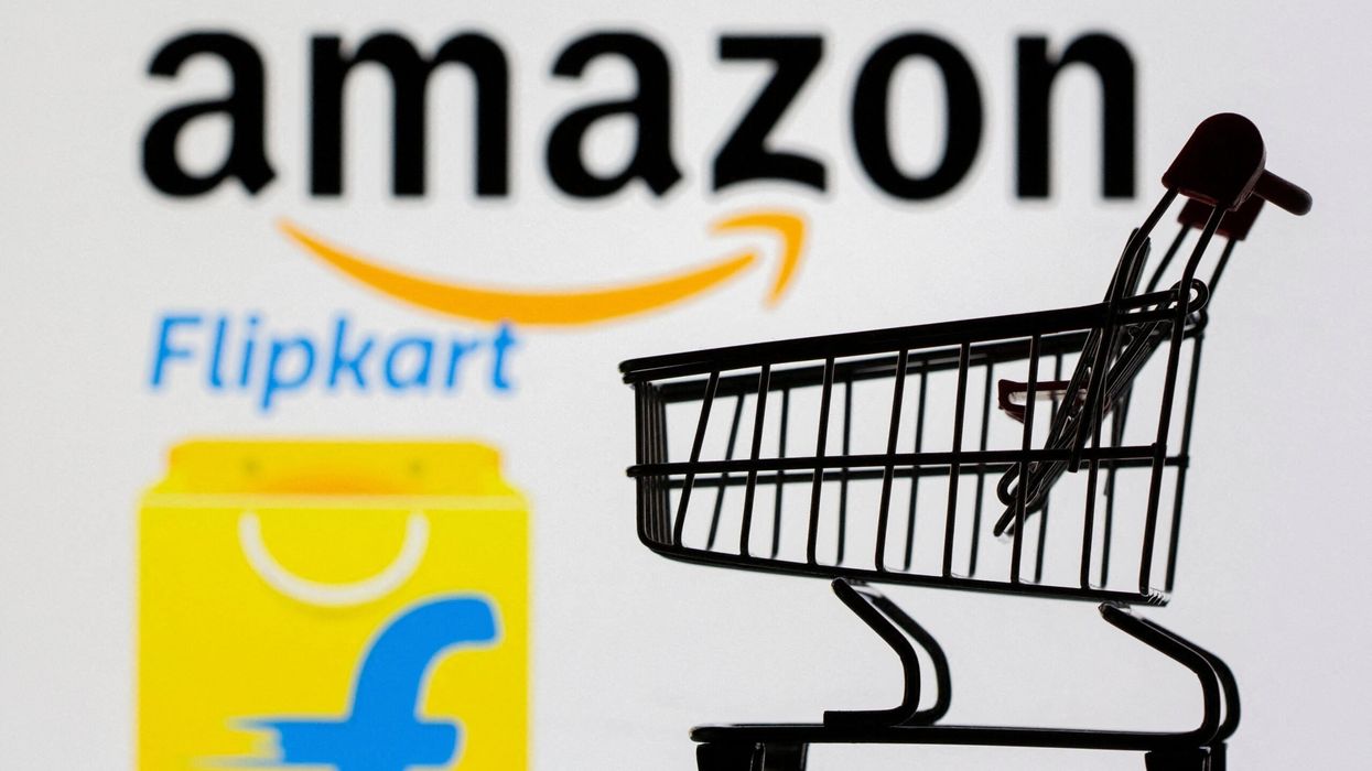 Small toy shopping cart is seen in front of displayed Amazon and Flipkart logos in this picture illustration. (Photo: Reuters)