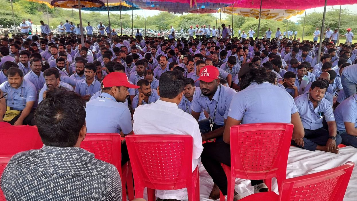 Workers of a Samsung facility speak with their union leader E Muthukumar during a strike to demand higher wages at its Sriperumbudur plant near the city of Chennai, India, on September 11. (Photo: Reuters)