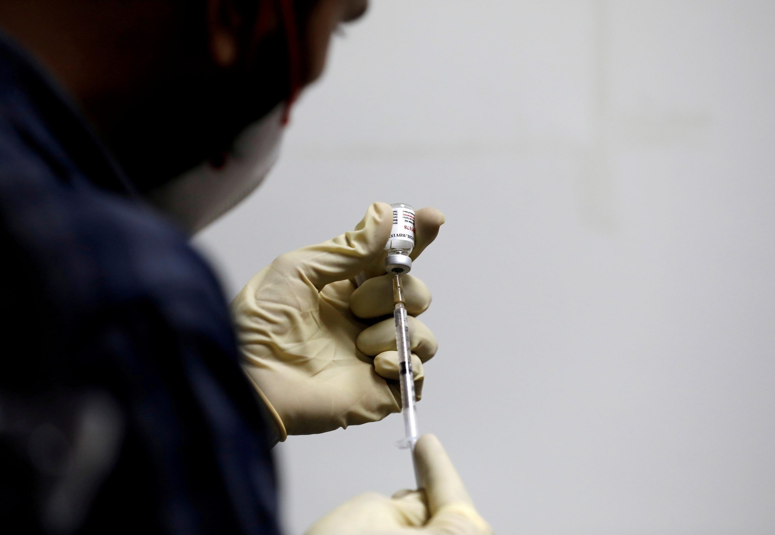 FILE PHOTO: A medic fills a syringe with COVAXIN, an Indian government-backed COVID-19 vaccine, before administering it to a health worker during its trials, at the Gujarat Medical Education and Research Society in Ahmedabad, India, November 26, 2020. REUTERS/Amit Dave/File Photo