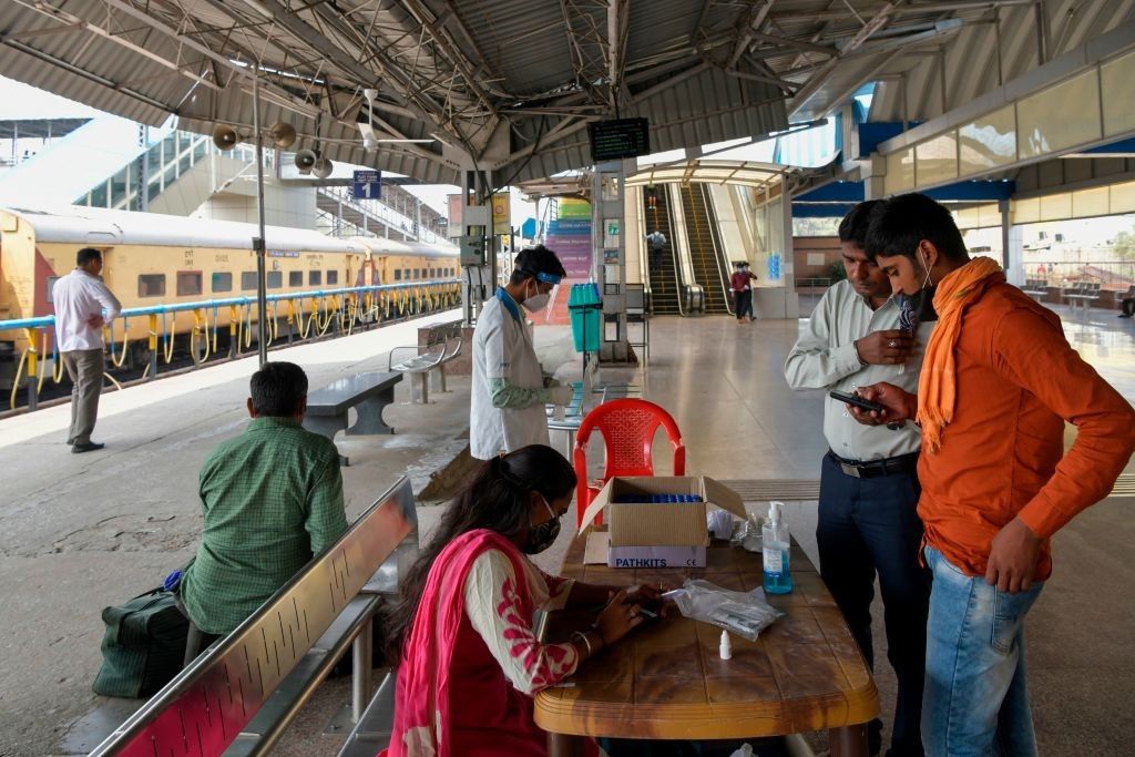 Passengers register before taking a nasal swab test for a Covid-19 coronavirus upon their arrival at at the Yeshwanthpur Railway Station, in Bangalore on February 18, 2021. (Photo by MANJUNATH KIRAN/AFP via Getty Images)