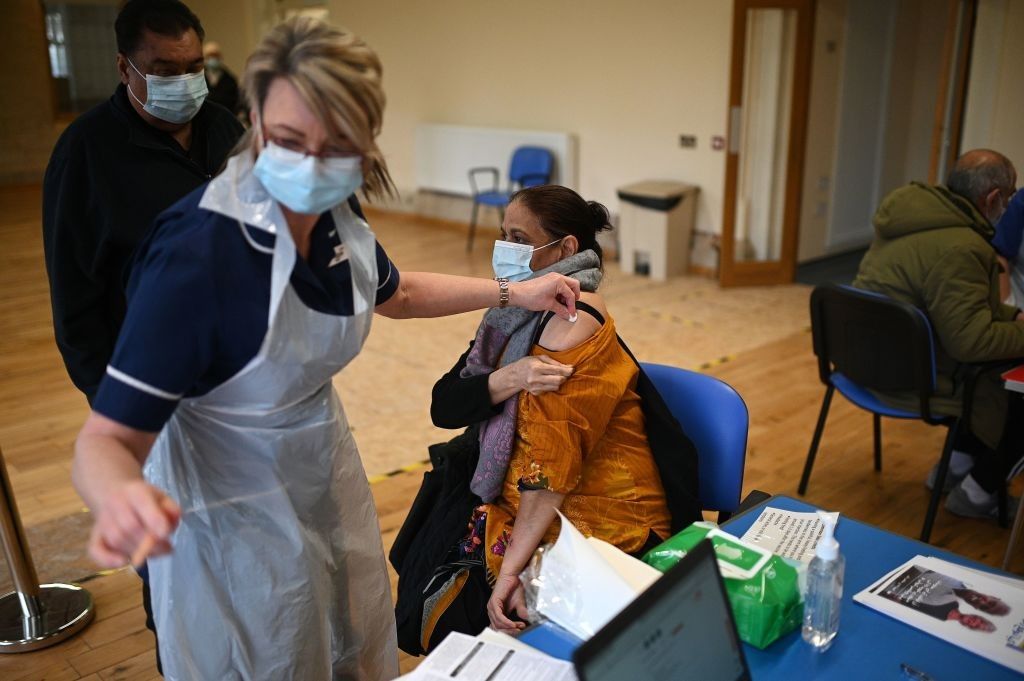 Nurse Maggie Clark administers a dose of the AstraZeneca/Oxford Covid-19 vaccine to a patient at a vaccination centre set up at the Fiveways Islamic Centre and Mosque in Nottingham, central England, on February 22, 2021. (Photo by OLI SCARFF/AFP via Getty Images)