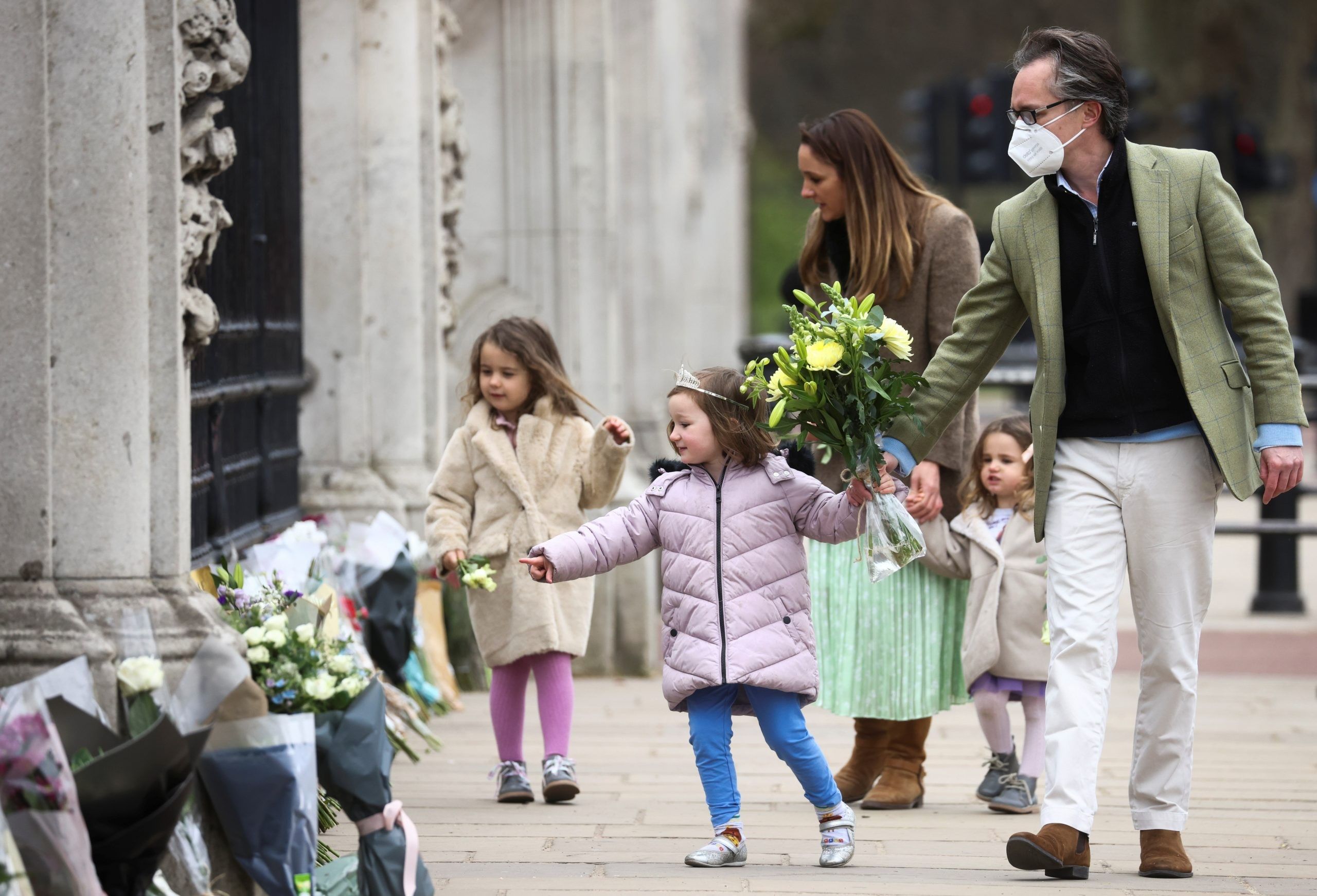 People bring flowers to Buckingham Palace after Britain's Prince Philip, husband of Queen Elizabeth, died at the age of 99. (Reuters Photo)