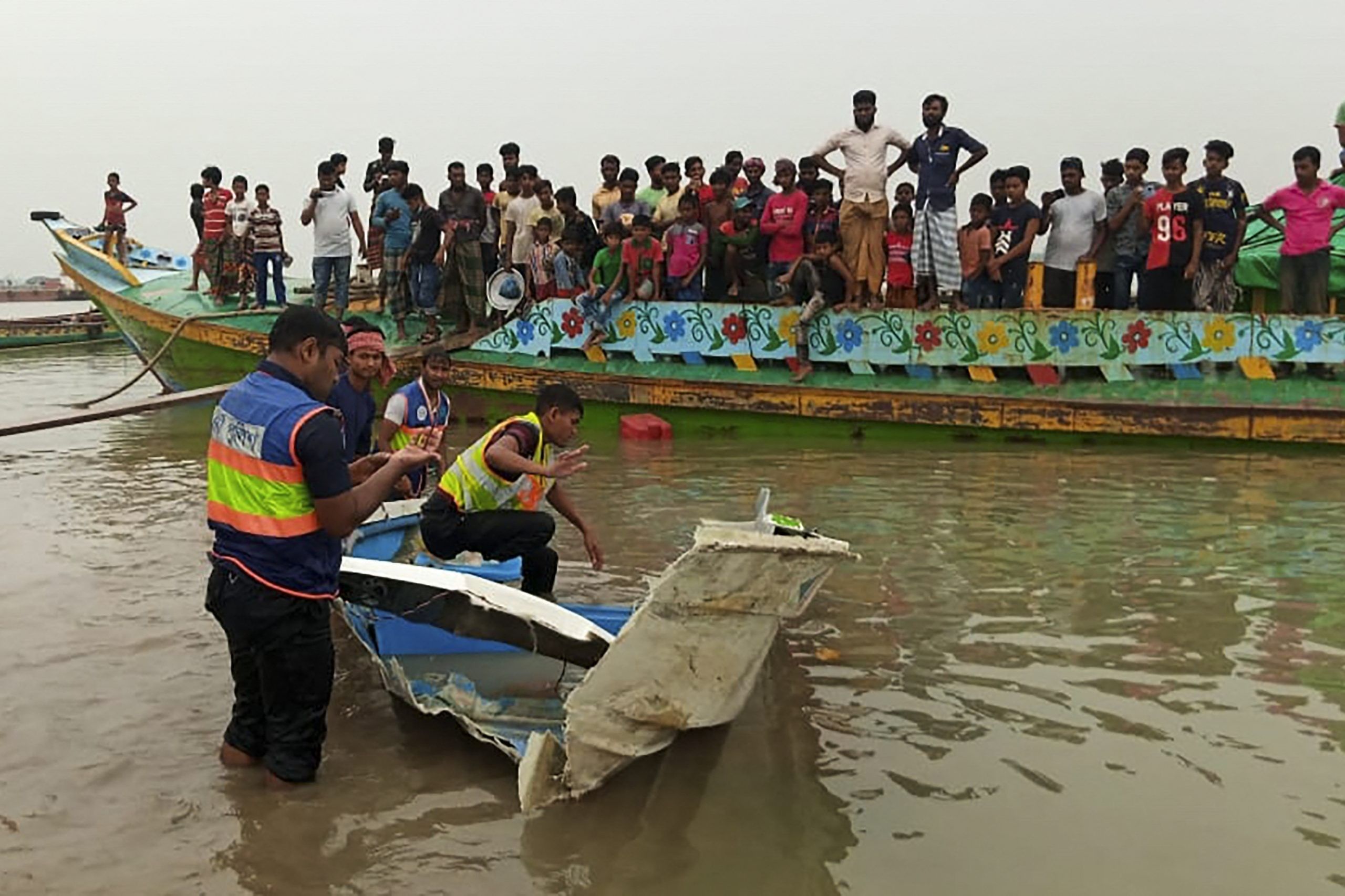 Policemen inspect a speed boat that was carrying passengers when it collided with a vessel transporting sand killing at least 26 people, in Madaripur on May 3, 2021. (Photo by - / AFP)