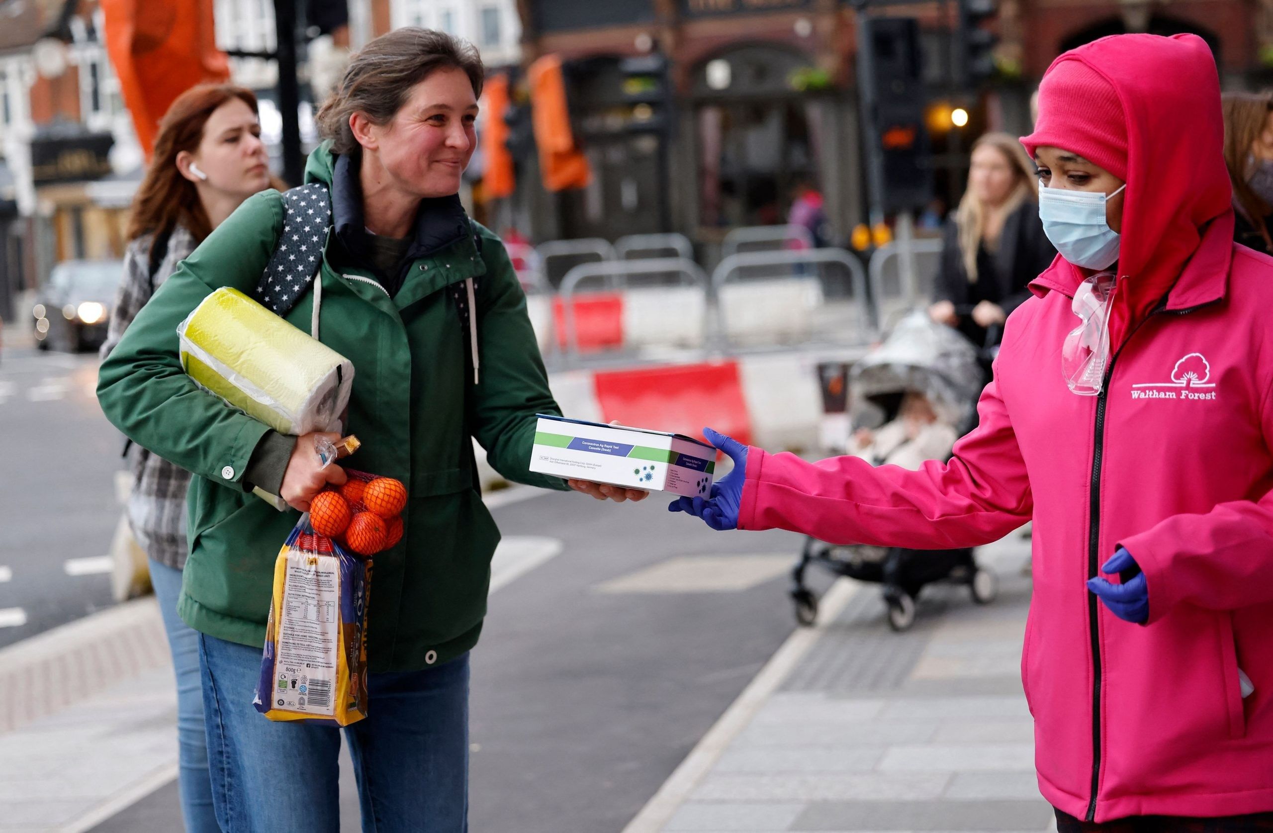 Volunteers hand out boxes of Lateral Flow Tests (LFT)