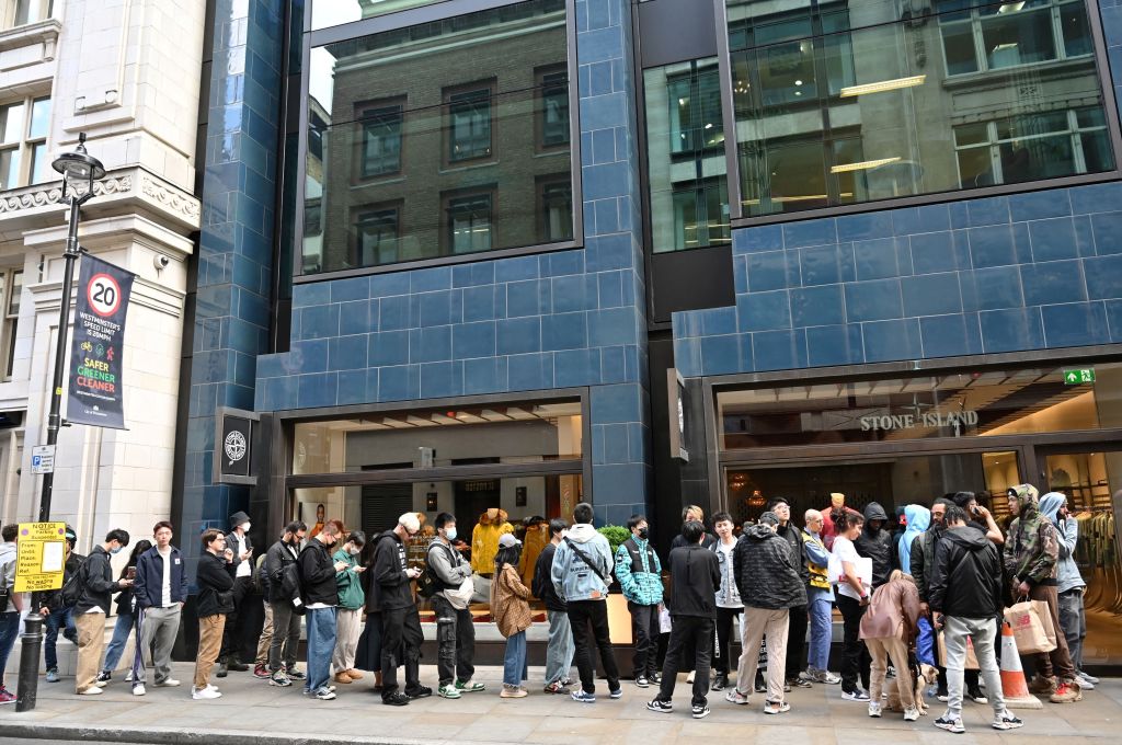 Customers queue to enter a Stone Island shop in London on May 12, 2022