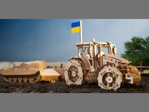A tractor carrying a Ukrainian flag manufactured by Ugears