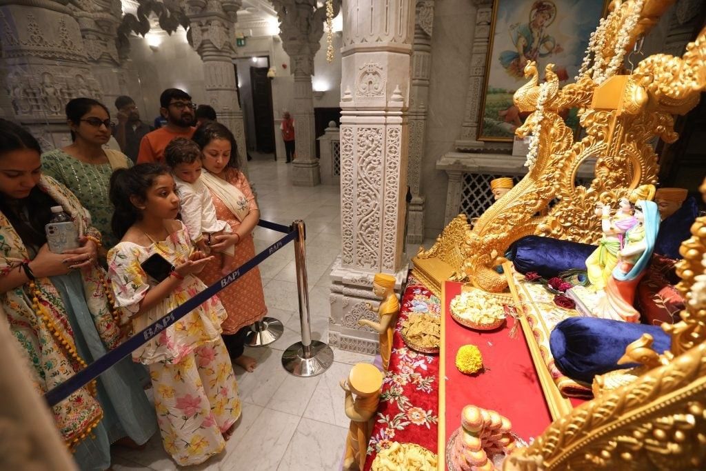 Neasden Temple celebrates Krishna Janmashtami 1 Devotees offering prayers and cradling the murti of Shri Krishna Bhagwan on a decorated swing